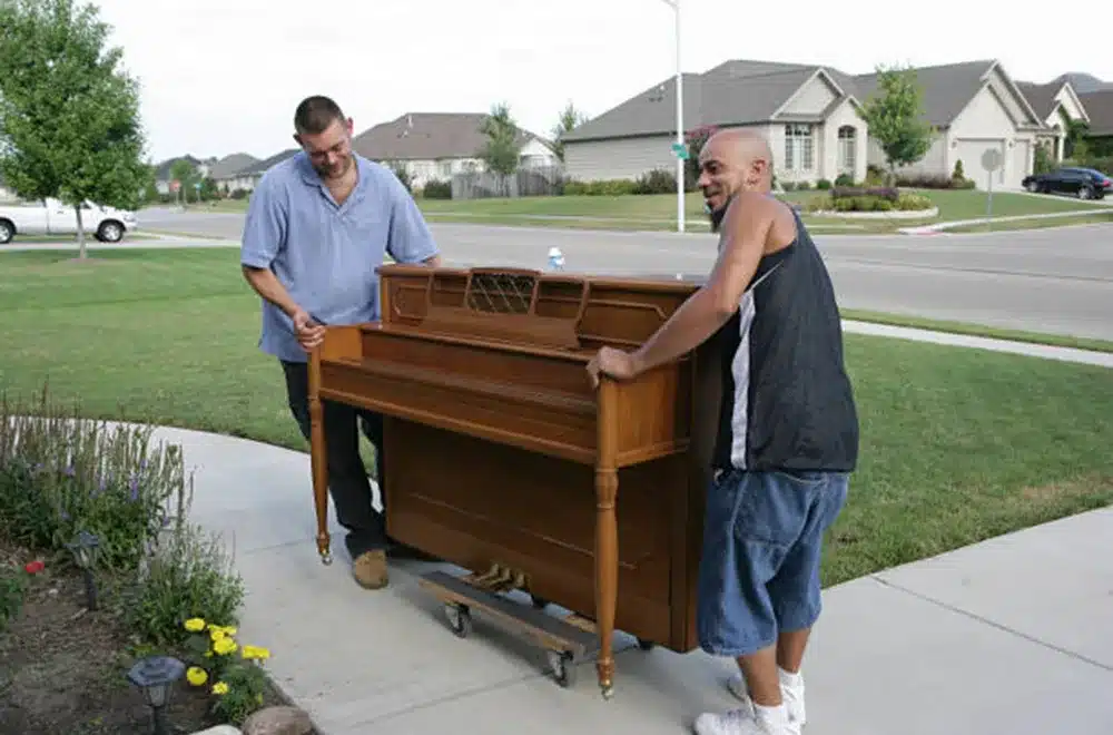 two guys moving an upright piano