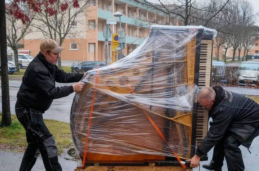 moving-piano-houston 2 people moving a piano in houston rain weather